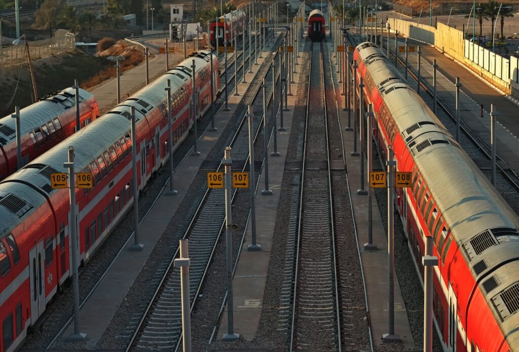 Passenger trains aligned at a railway station captured from above, showcasing transportation infrastructure.